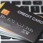 A credit card and others cards placed on a laptop keyboard.