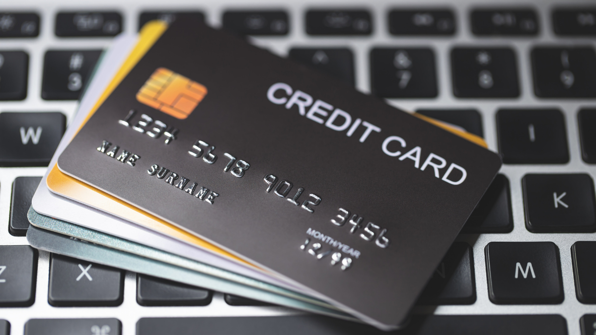 A credit card and others cards placed on a laptop keyboard.
